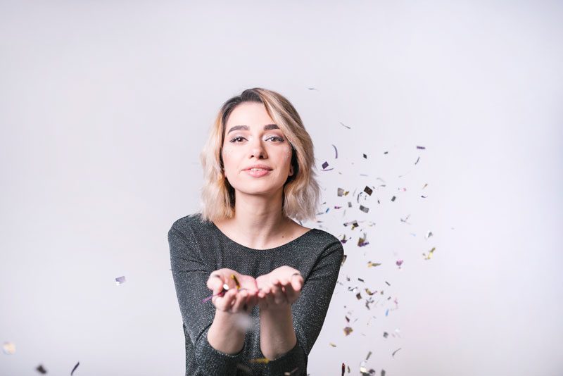 Woman blowing confetti